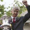 The Arsenal manager Arsene Wenger holds the FA Cup during Sunday's victory parade in north London.